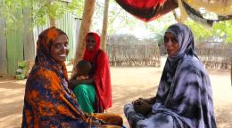 Three women in Kenya smile and laugh.