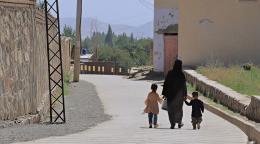 امرأة في أفغانستان تمسك بأيدي ابنها وبناتها.