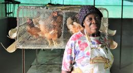 A woman farmer in Namibia in front of her chickens.