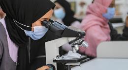 امرأة في ليبيا تنظر من خلال المجهر.