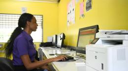 A woman in Jamaica uses a computer.
