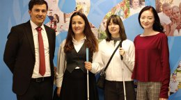 Добровольцы ООН стоят на фоне плаката