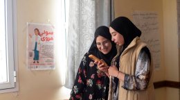 Deux filles regardent un téléphone portable.
