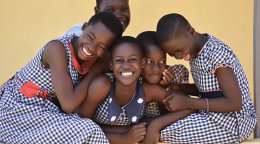 Five girls in Côte d'Ivoire smile for a photo.