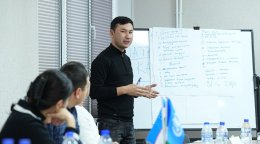 Молодой человек проводит презентацию для небольшой аудитории.