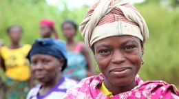 A woman in Benin stands in front of other women.