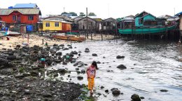 A girl in the Philippines walks near the coast.