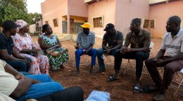Un volontaire des Nations Unies s'entretient avec des membres de la communauté locale au Burkina Faso.