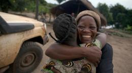 Two smiling people hug. 