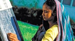 Imagen de una mujer con un velo tejiendo.