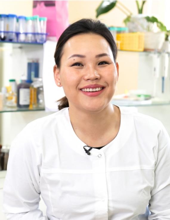 Молодая женщина ученая в лаборатории улыбается на камеру