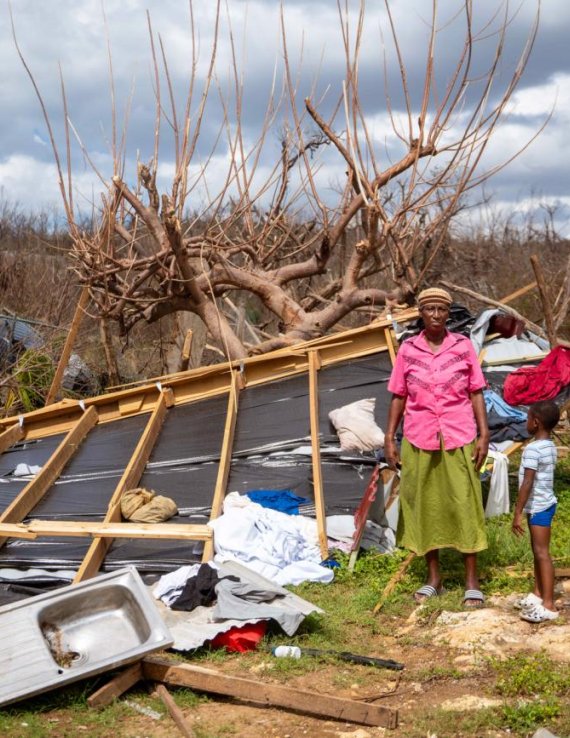 Una mujer y un niño junto a los restos de una vivienda destruida en una zona afectada por el huracán Melissa