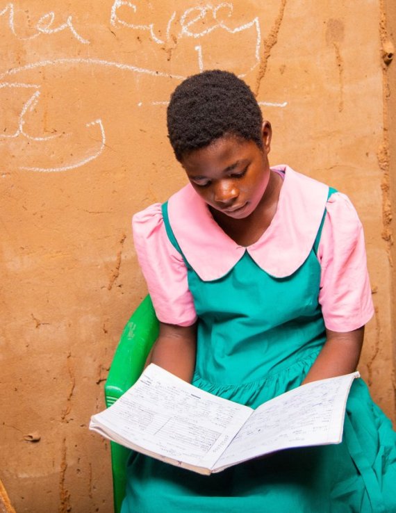 A girl in Malawi reads a book.