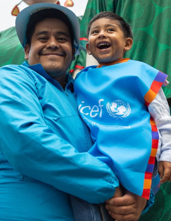 A man in Mexico holds his son.