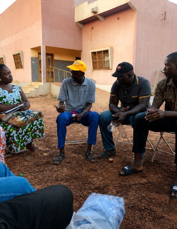 Un volontaire des Nations Unies s'entretient avec des membres de la communauté locale au Burkina Faso.