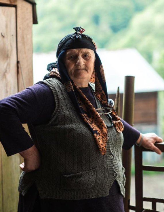 Женщина опирается на забор.
