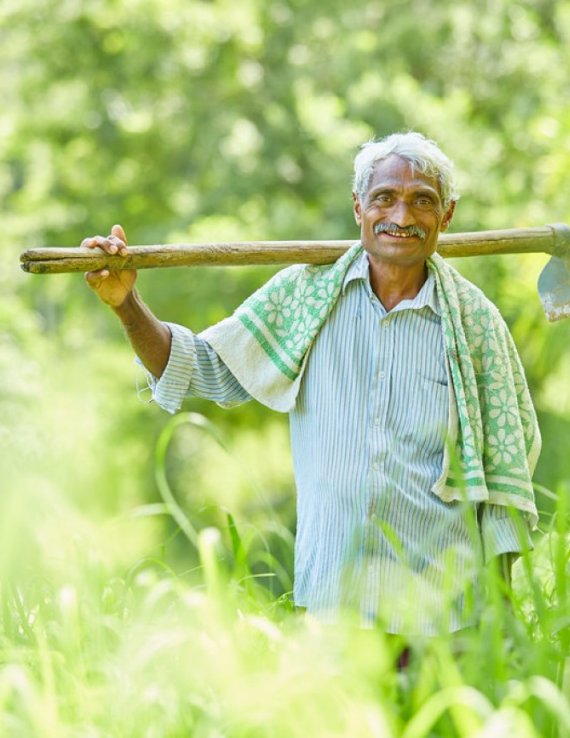 Farmer carries a tool in a field