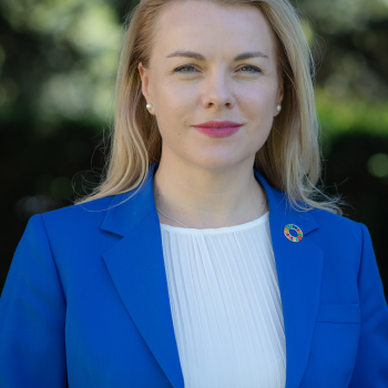 A woman with blonde hair in a blue suit jacket and white shirt