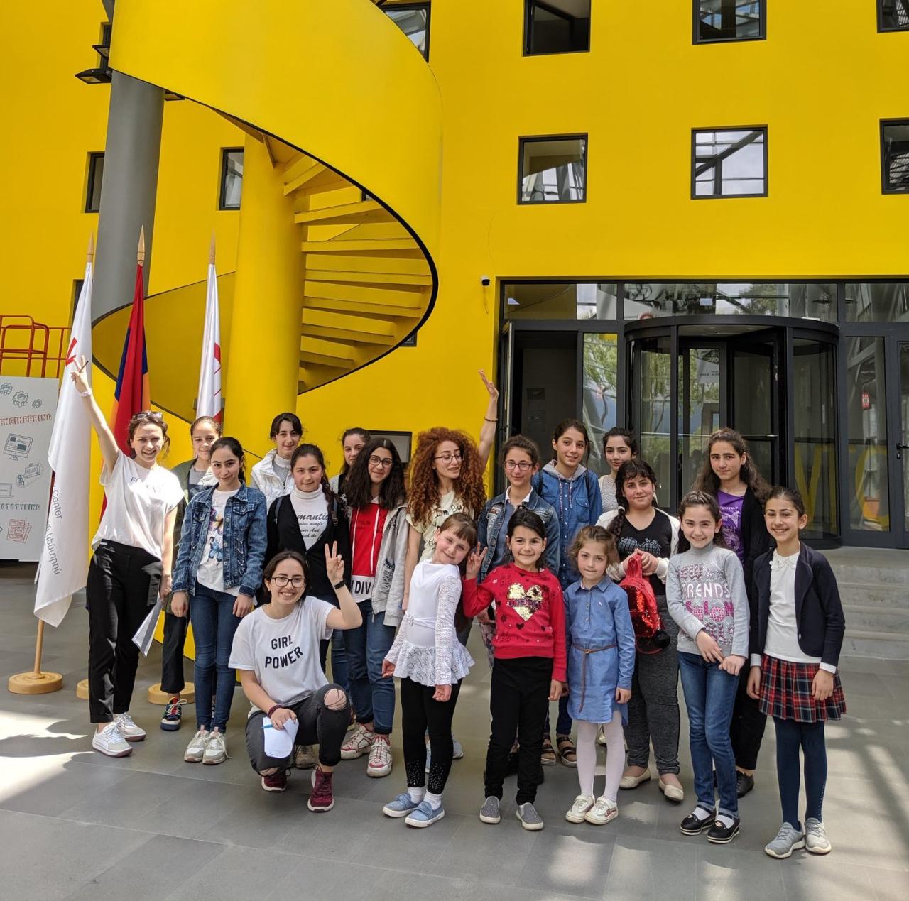 Girls stand outside the buidling