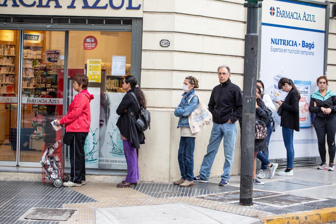People wait in line outside a pharmacy in Argentina.