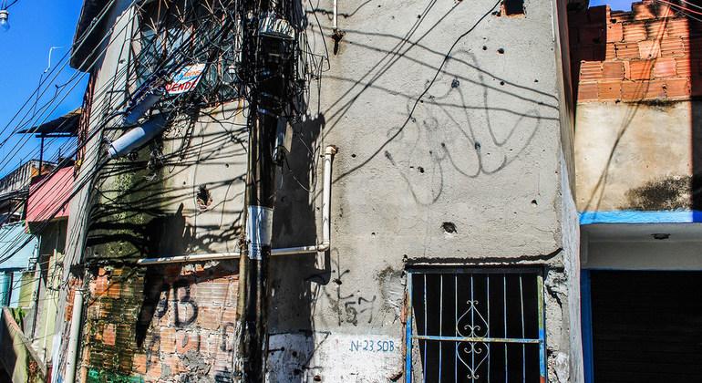 The walls of a home shot multiple times displays the word peace.