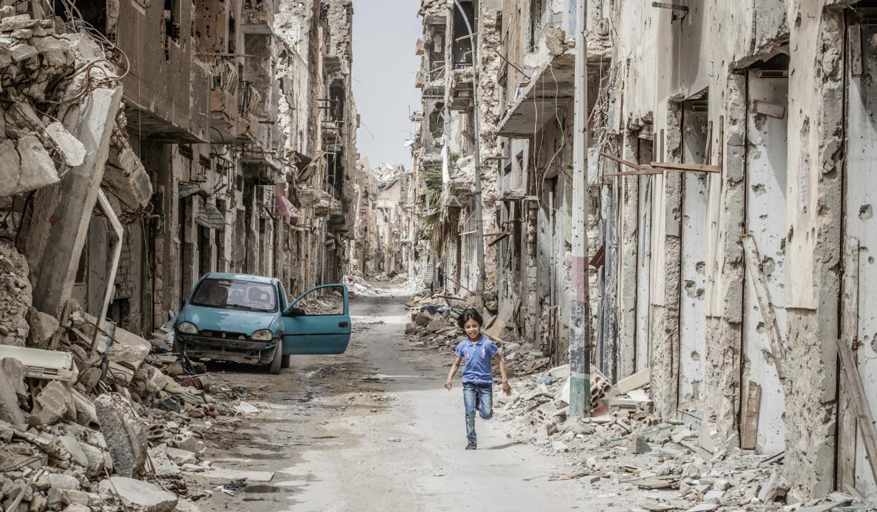 Un niño corre a través de los escombros y restos en el centro de Bengasi, Libia.