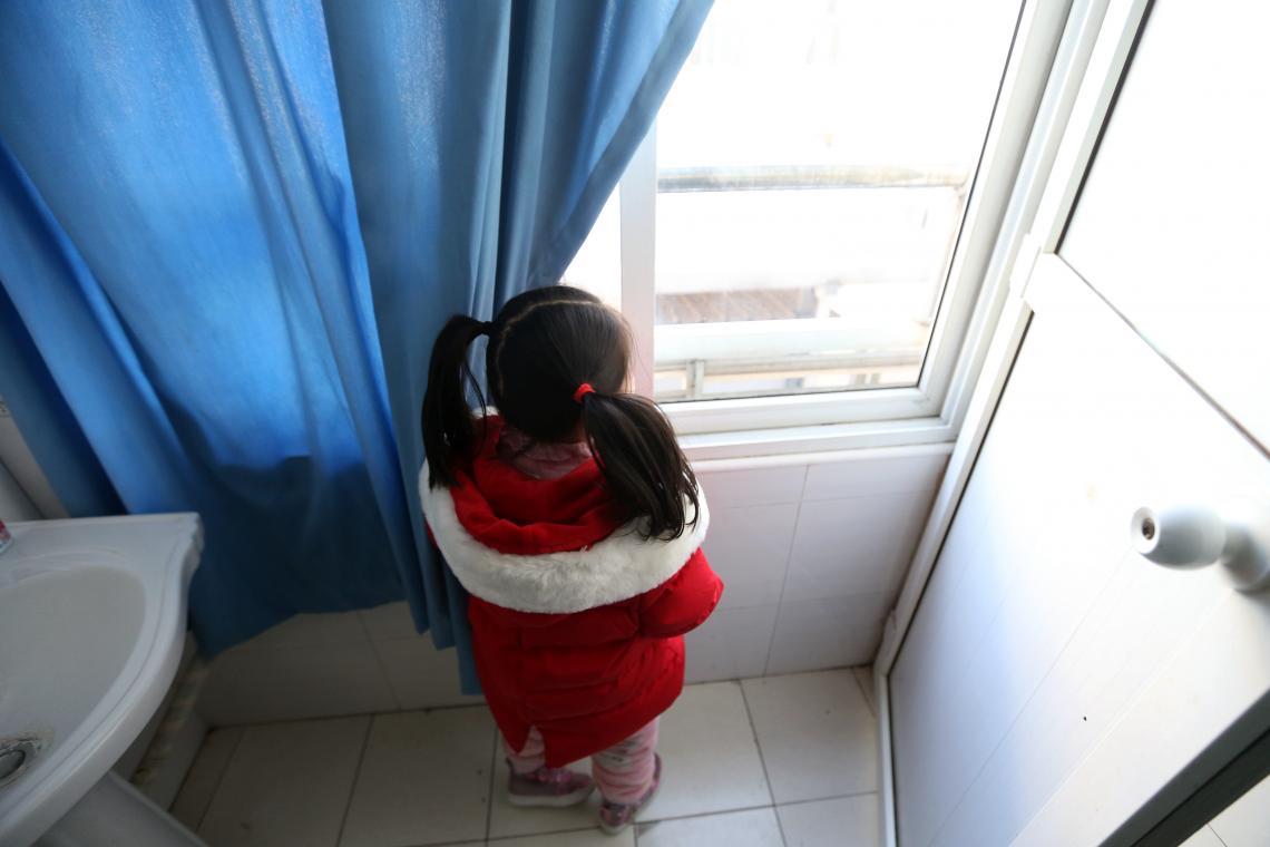 Little girl looks out the window. 