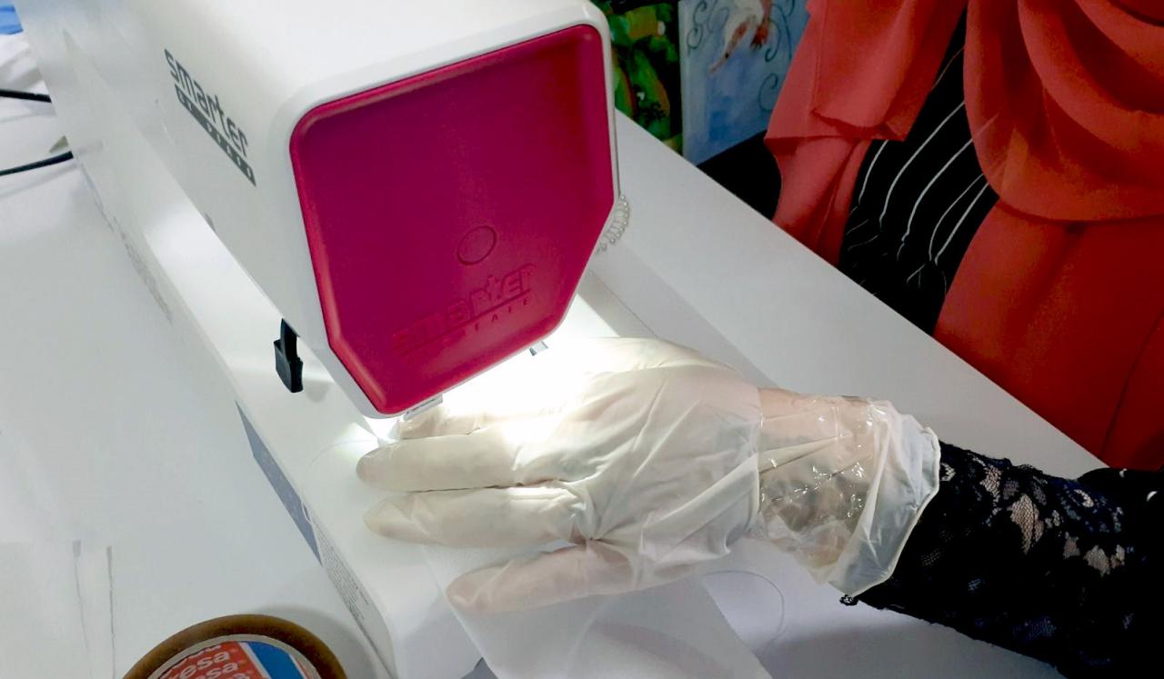 Closeup of hands sewing protective masks.