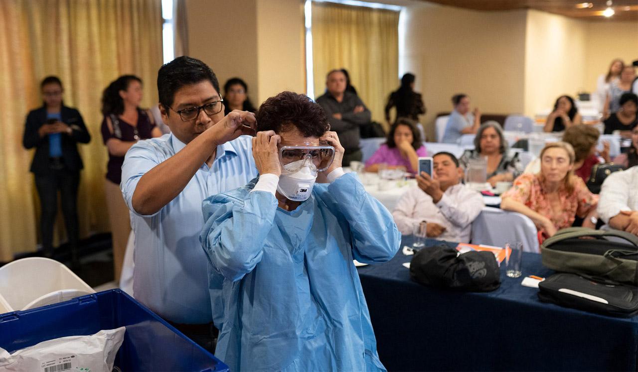 Men demonstrate how to properly put on protective gear.