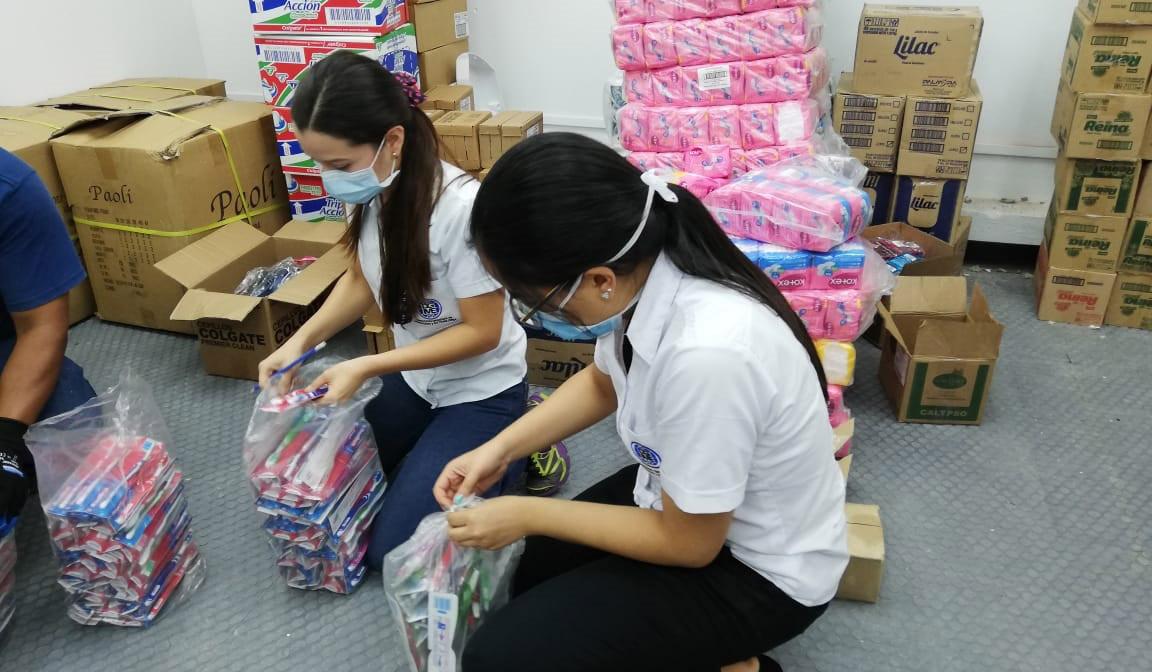 Los cepillos de dientes y las toallas higiénicas se clasifican para empaquetar kits de dignidad para las mujeres en las prisiones y centros de cuarentena.