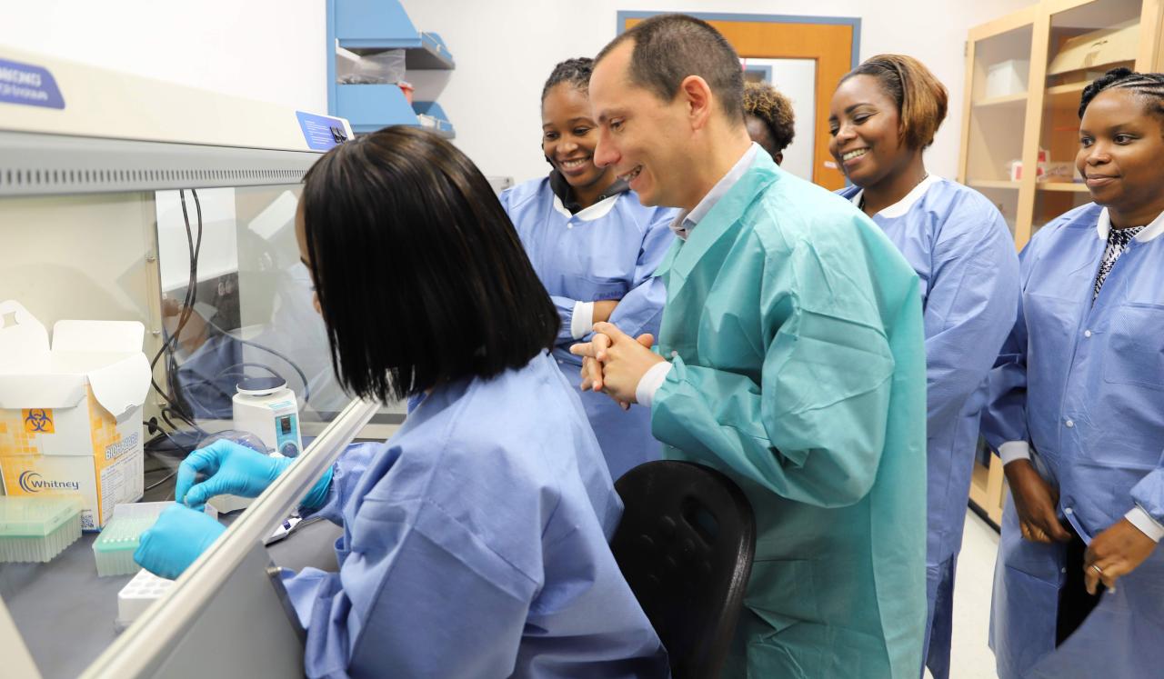Laboratory Technologist being observed by Dr Gresh, Laboratory Director and other colleagues.