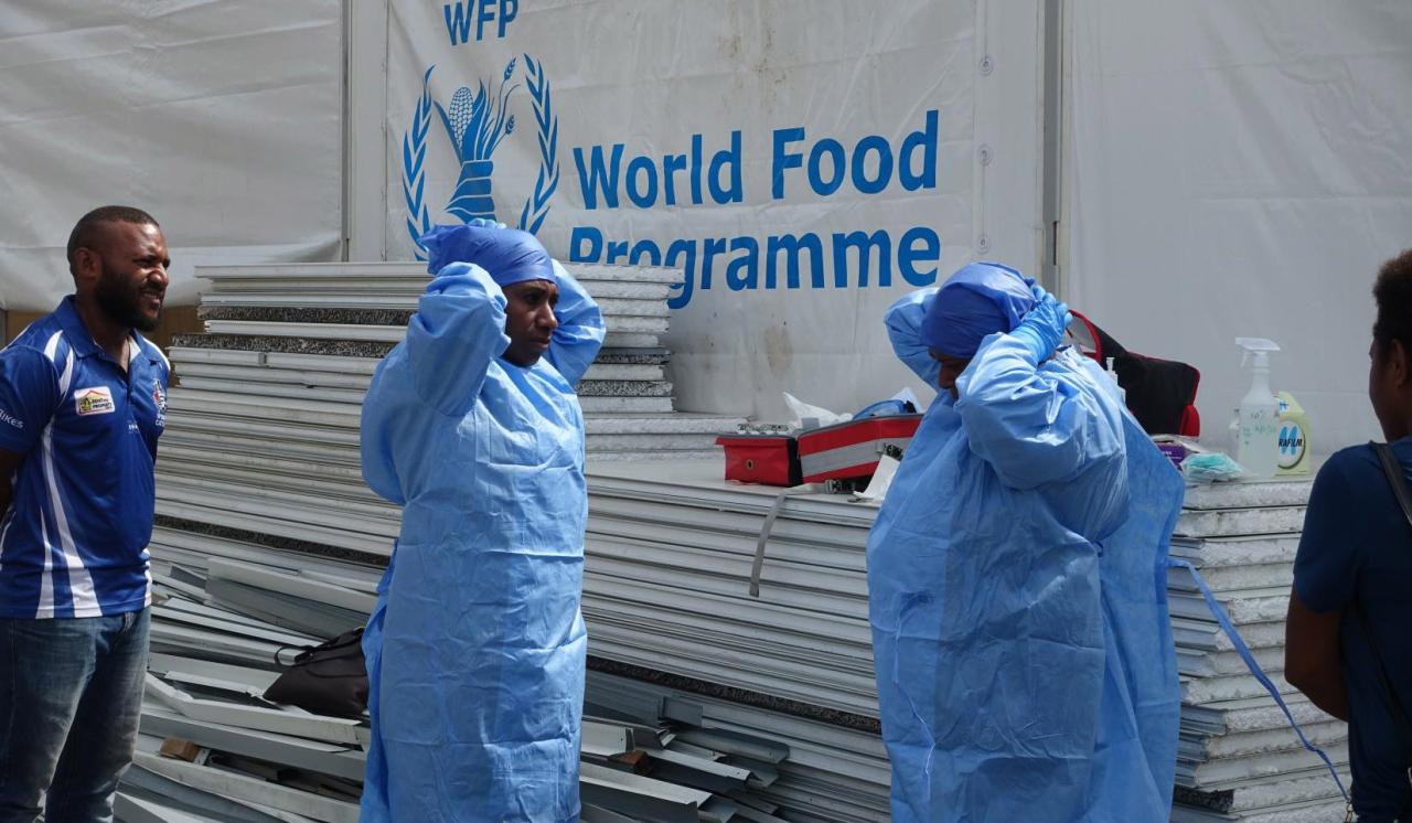 Los trabajadores sanitarios de NCD practican la colocación del EPI antes de un simulacro para los medios de comunicación y los invitados en una instalación de pruebas y aislamiento de la COVID-19 en Port Moresby.