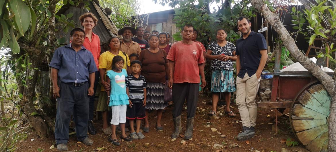  Des hommes, des femmes et des enfants se tiennent debout, face caméra, sous un arbre, dans le territoire luxuriant de la province de Puntarenas.