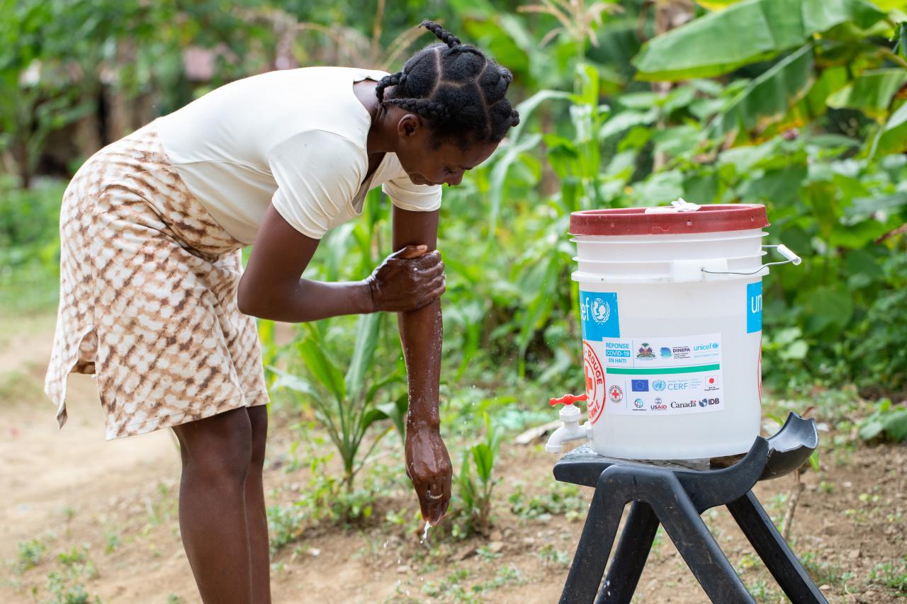 Raymone Notus, 39, washes her hands at a handwashing station in Sevré, Haiti.