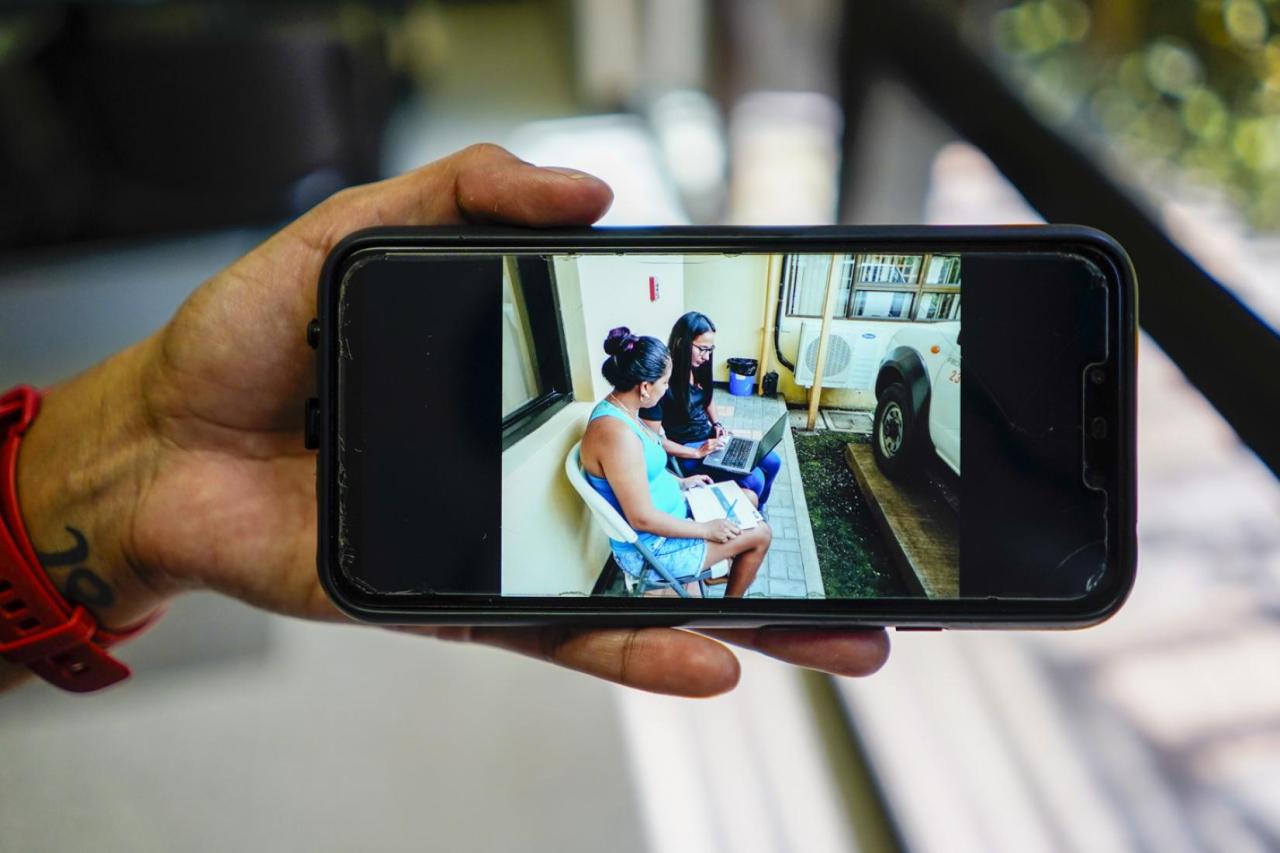 Close up of image from an iPhone of Gabriela sitting with one of her clients outside.