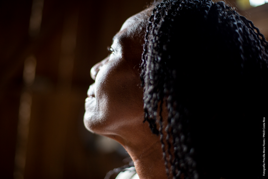The profile of a woman's face as she stares out pensively. 