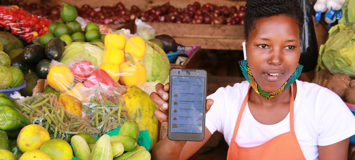 A market vendor exhibits the Safeboda app. 