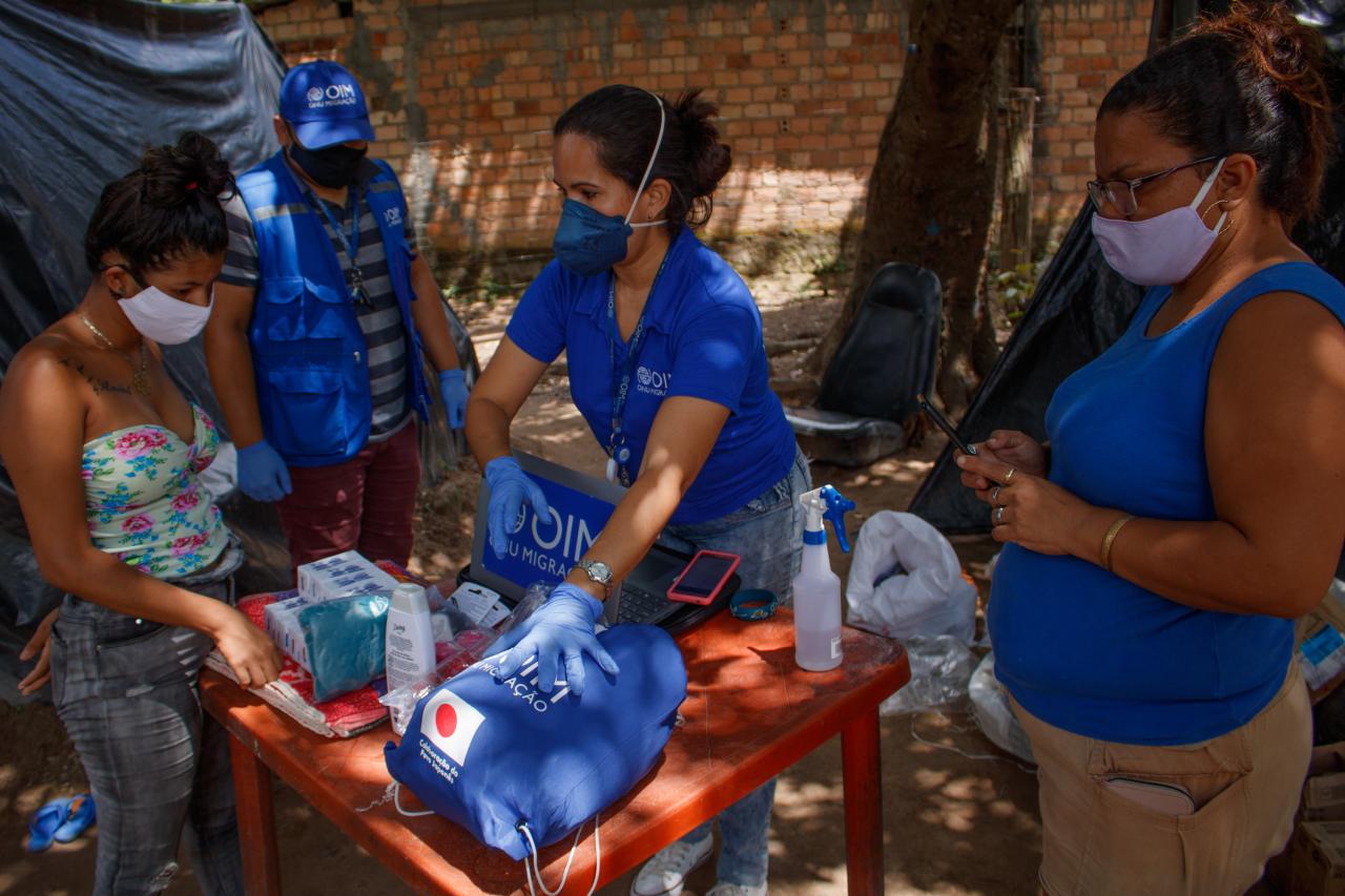 IOM staff explain to residents what each donated essential kit contains.