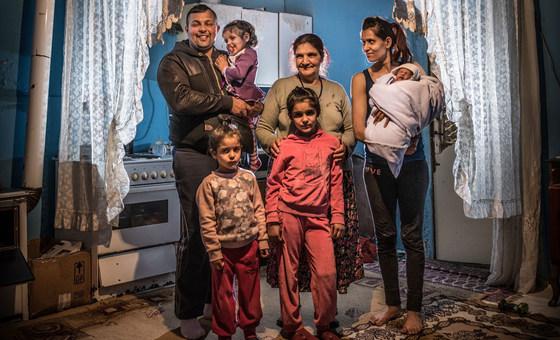 Les membres d'une famille posent tous ensemble devant la caméra, dans leur maison, à Belgrade.
