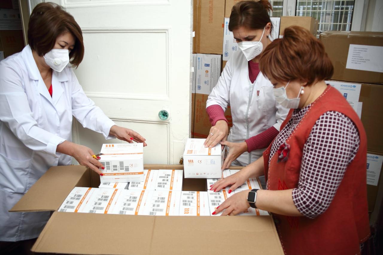 Healthcare workers open boxes of donated syringes and essential supplies to support those of higher risk, including those with diabetes.