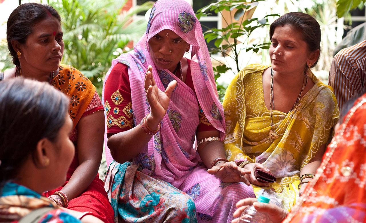 Photo shows a group of Indian women sitting together having a conversation.