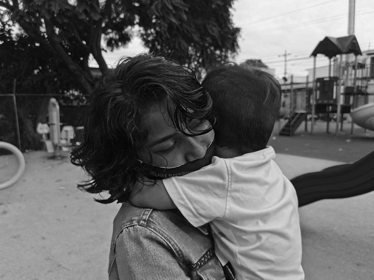 Lilith closes her eyes as she embraces her young son. 