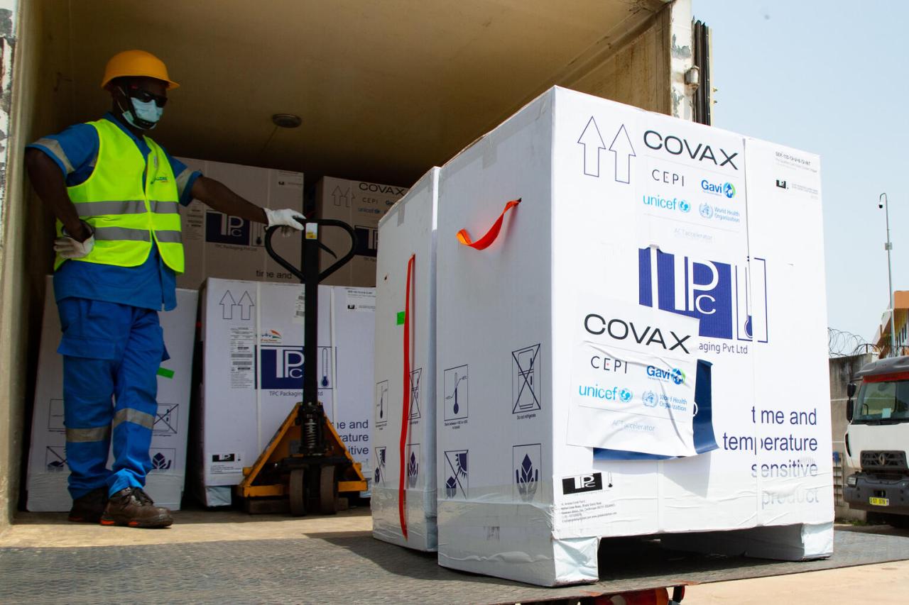 Photo shows a warehouse staff member proudly unloading boxes of vaccines from a truck.