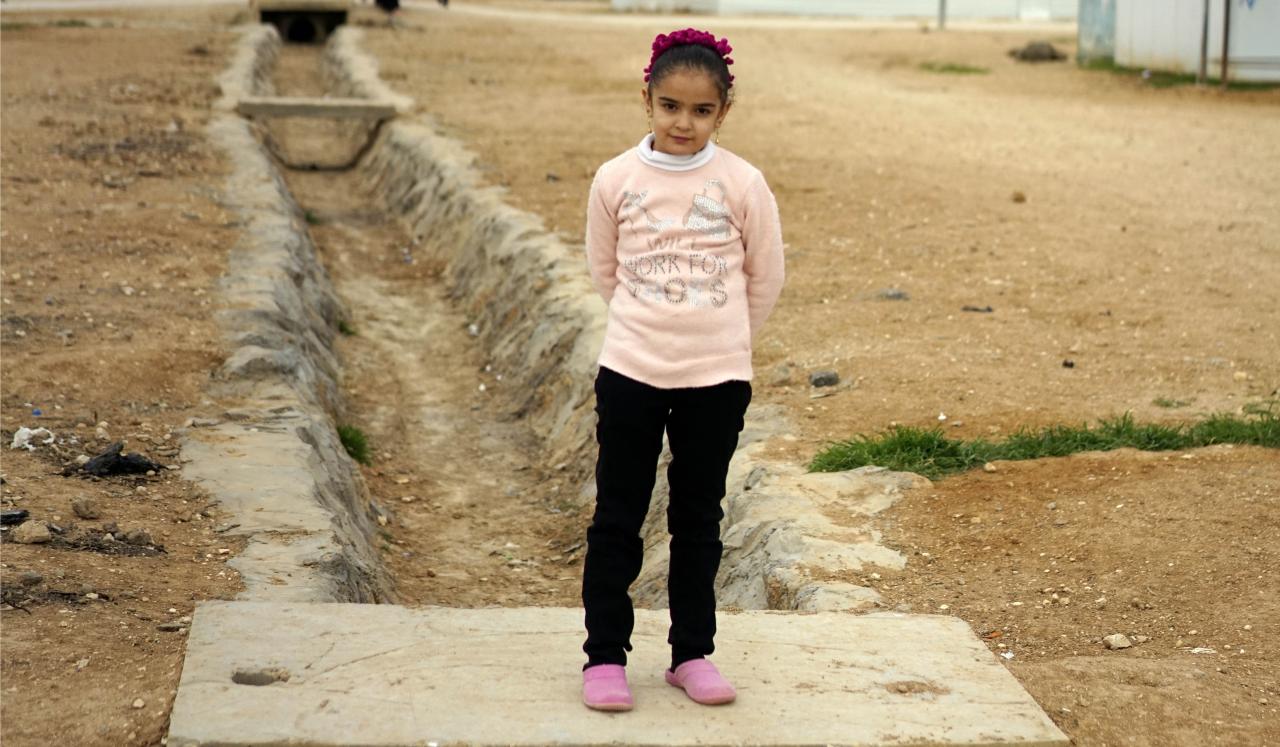 Laila, 10 stands outside across from her home. 