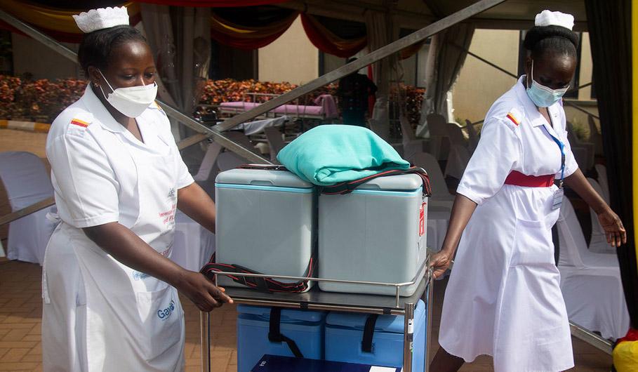 Two women in medical outfits cart around medical supplies. 