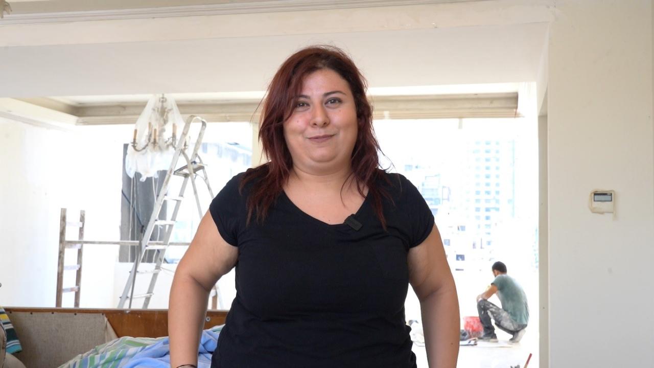 A woman in a black shirt looks at the camera.