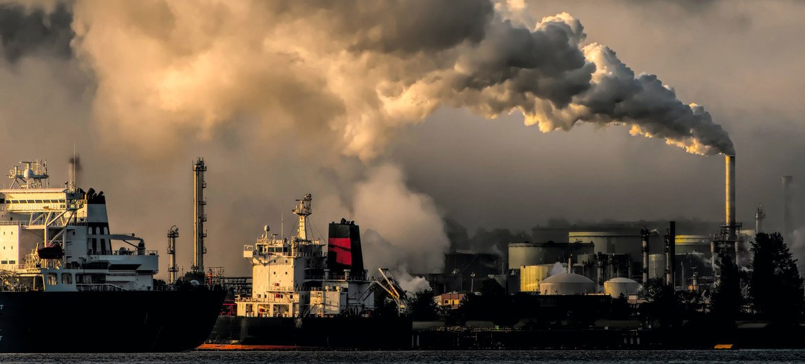 Vue d'une zone indsutrielle où l'on voit des usines rejeter des gaz polluants.