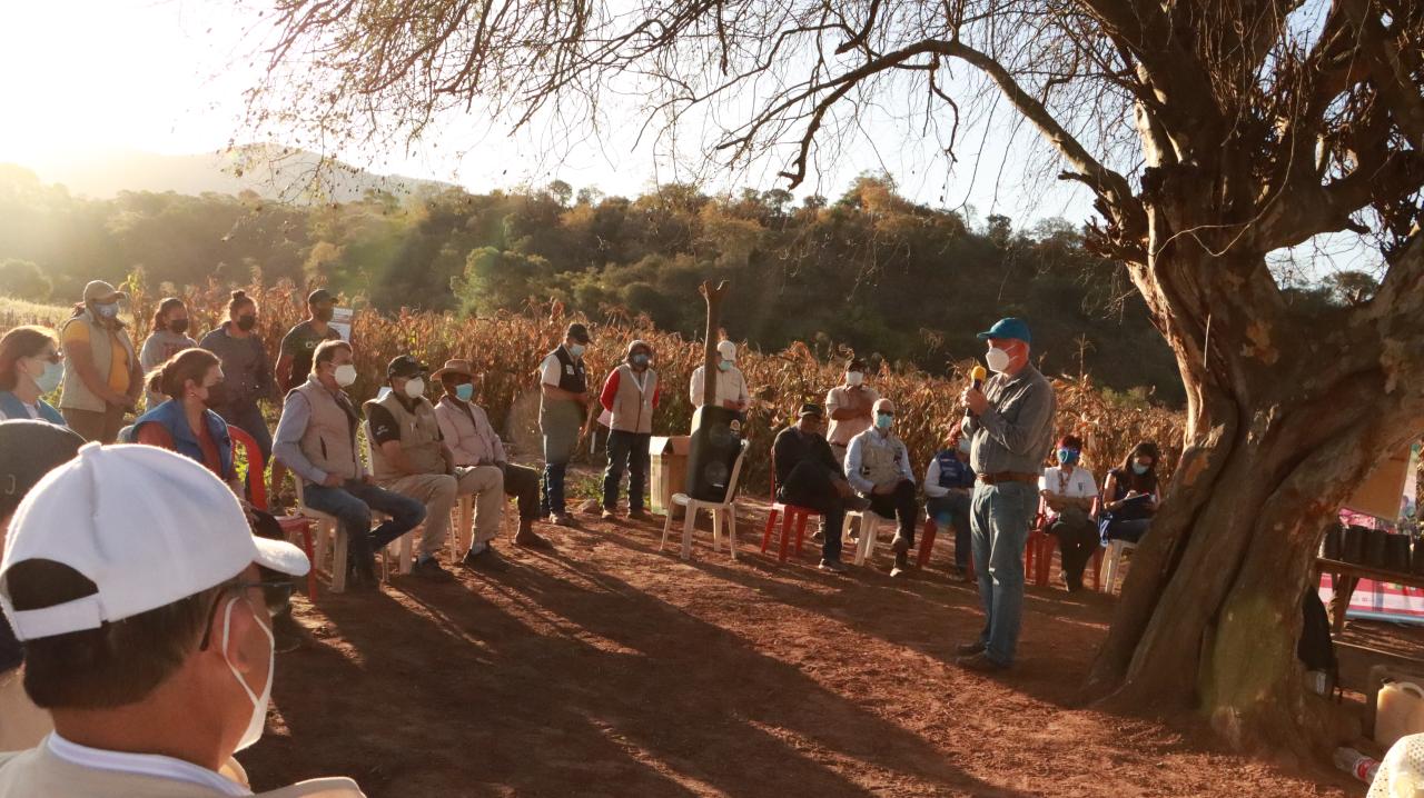 Un grupo de personas en un escampado duranta la visita al centro demostrativo de capacitación de la comunidad Arenal en Bolivia.