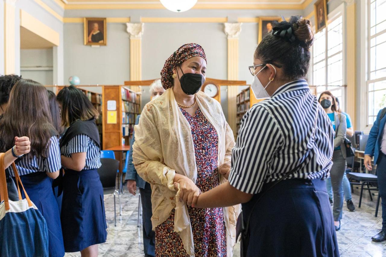 La Vicesecretaria General, Amina J. Mohammed, de pie junto a un grupo de estudiantes y cogiendo de la mano a una de ellas en la biblioteca del Colegio de Señoritas de Costa Rica.