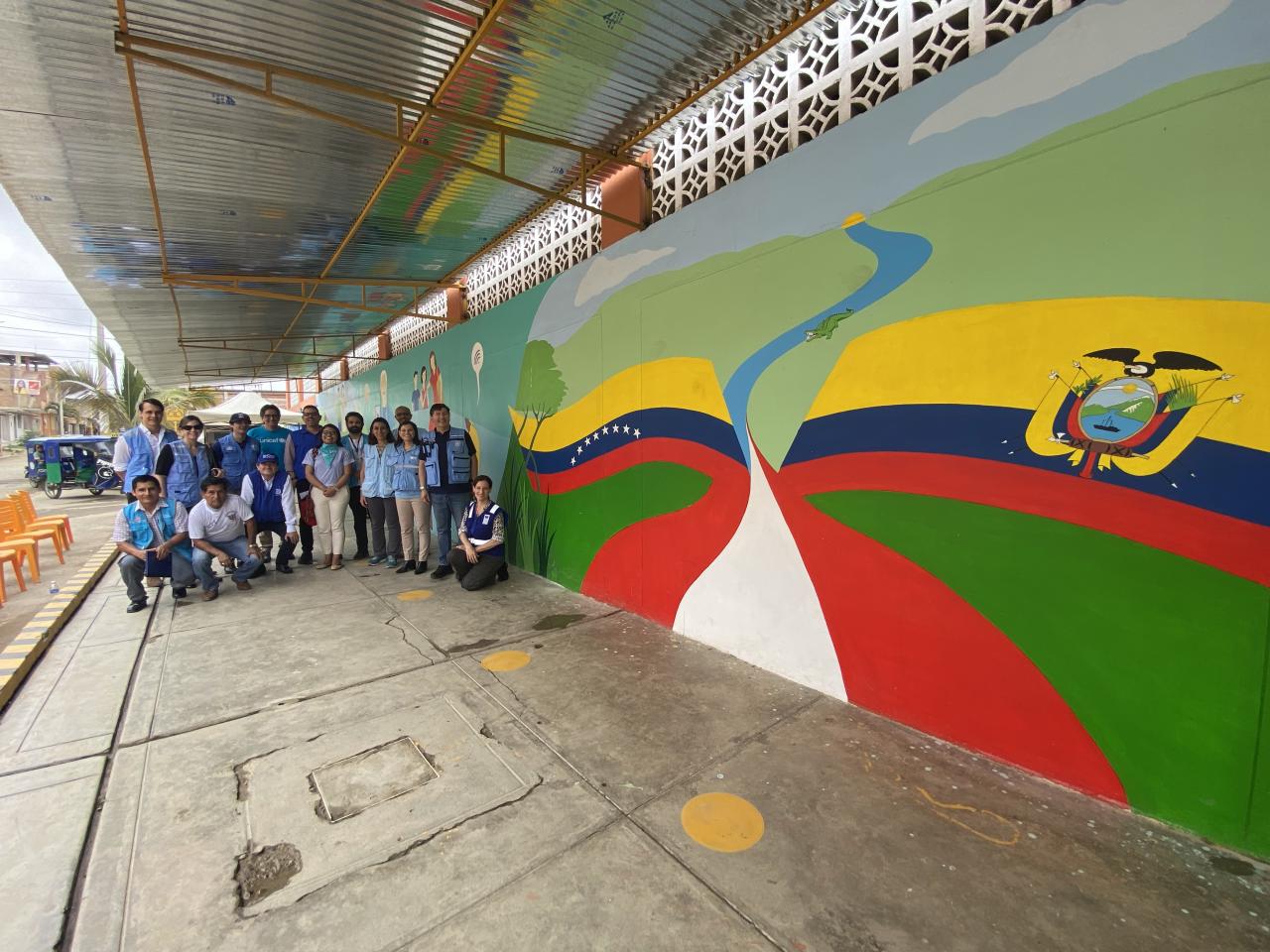 Miembros de una delegación internacional de las Naciones Unidas de pie frente al mercado 8 de Septiembre en Perú.